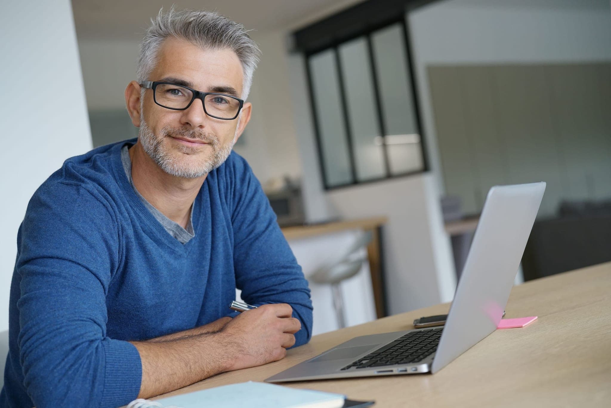 Mid-market business owner at his desk considering his exit and succession options