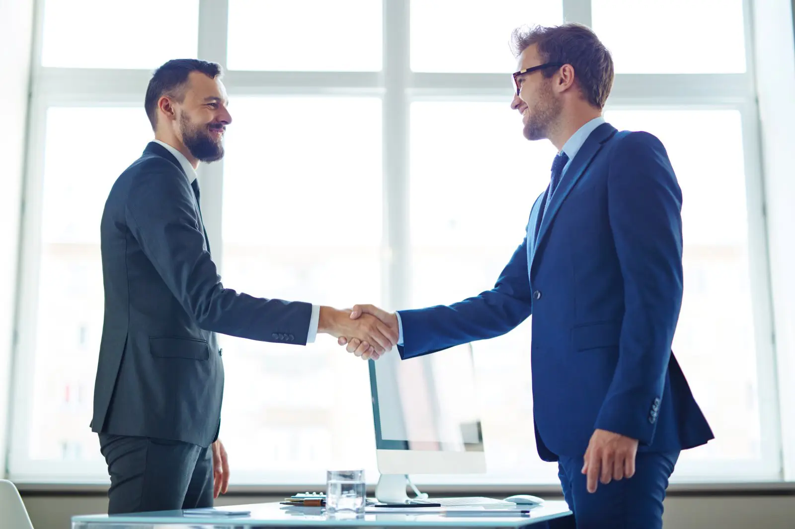 Two business professionals shaking hands to close a sale