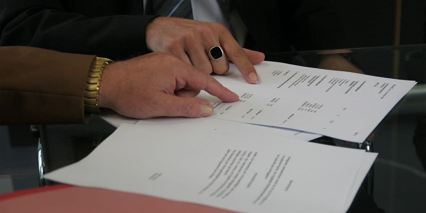 Two people reviewing and signing an agreement at a desk