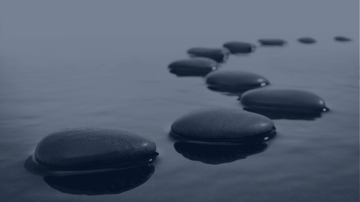 Stepping stones across calm water, symbolising the path to a business sale