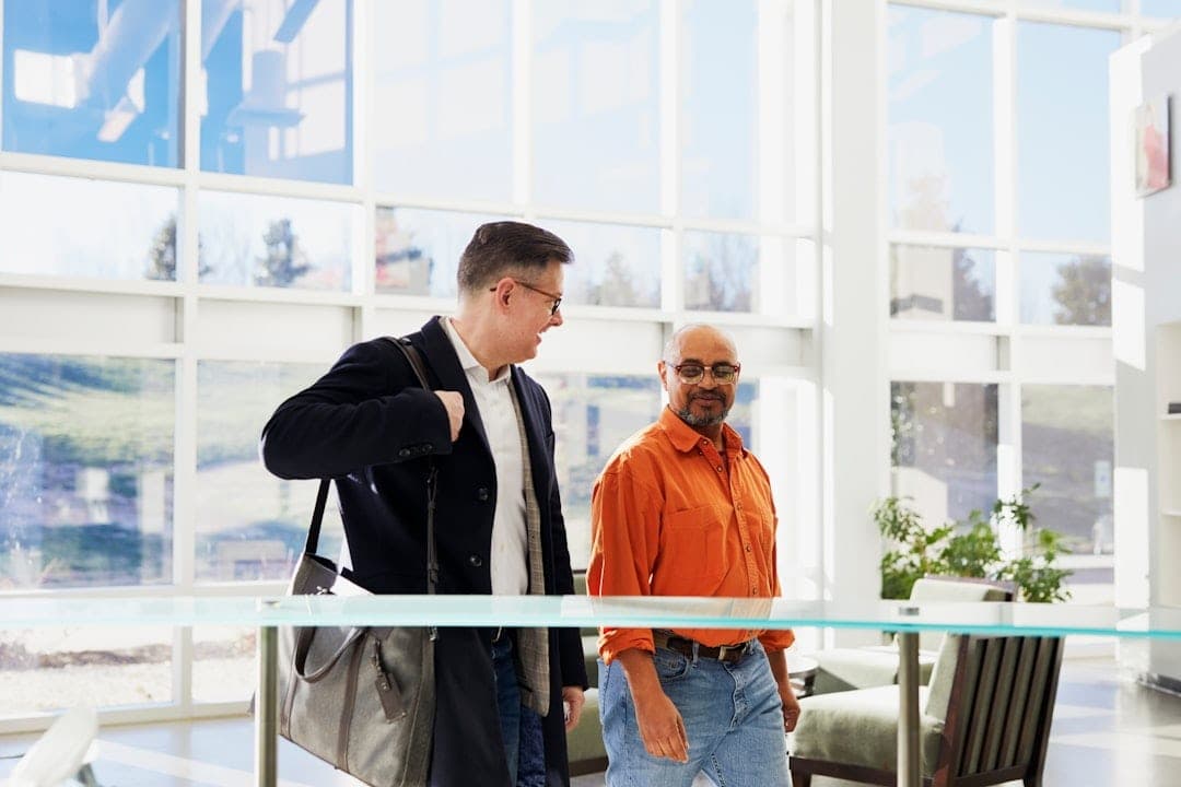 Two professionals talking in a bright office lobby